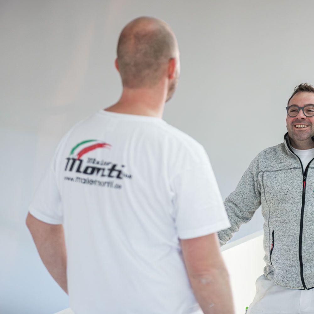 Inhaber Andrea Monti unterhält sich mit Angestellten auf einer Baustelle in Tegernsee