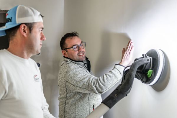 Maler Andrea Monti und MItarbeiter verputzen eine Innenwand in einem Neubau am Tegernsee