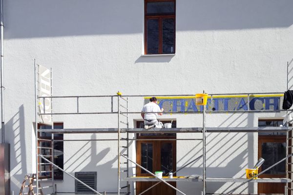 Malerarbeiten an der Fassade des Bahnhofs in Schaftlach durch Maler Monti auf einem Gerüst
