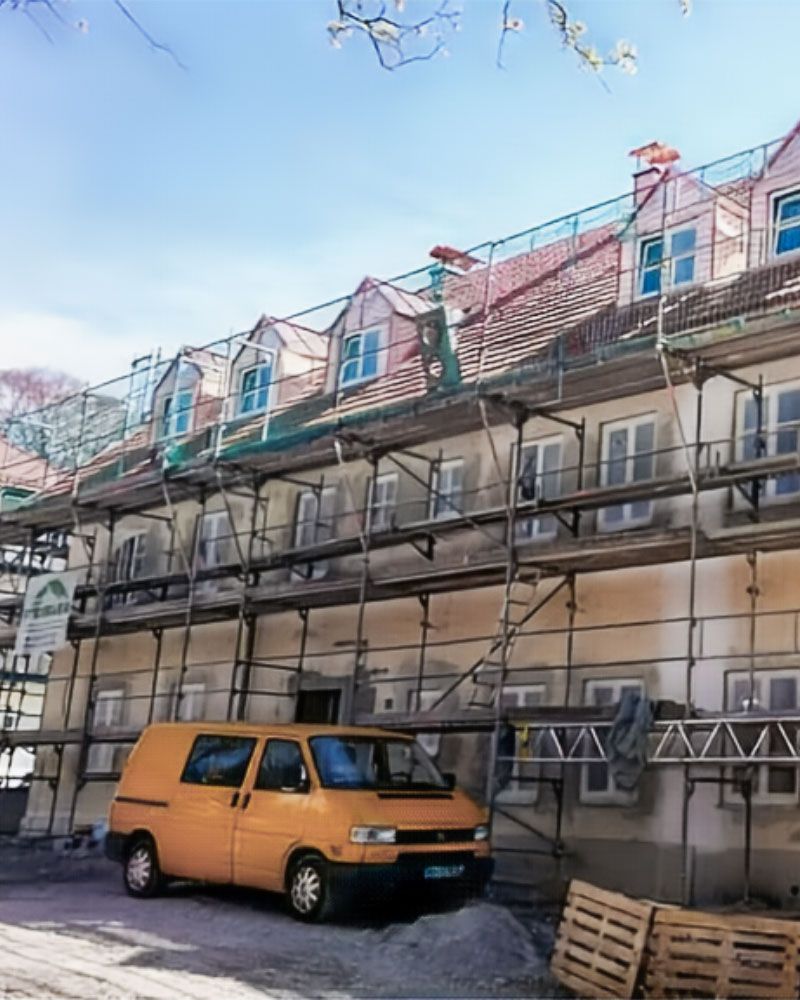Foto einer Baustelle der Firma Maler Monti mit altem Gebäude, Gerüst und Firmenwagen