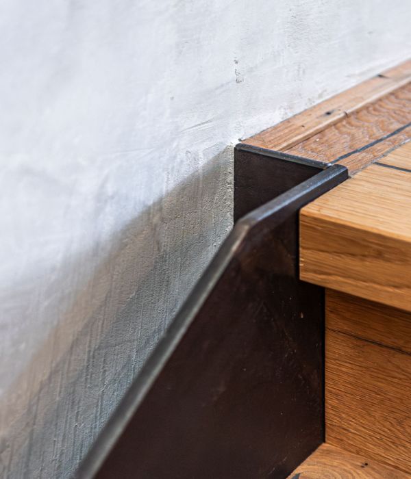 Detail eines renovierten Treppenaufgangs eines Hauses am Tegernsee, die Wand ist in Betonoptik von Maler Monti gespachtelt