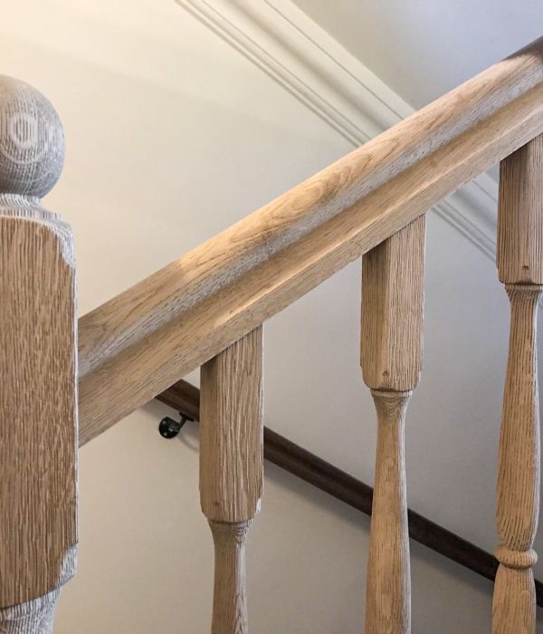 Geländer eines Treppenhauses in einem Haus am Tegernsee, an dem mit Hilfe der Sandstrahltechnik von Maler Monti alte Farbe entfernt wurde